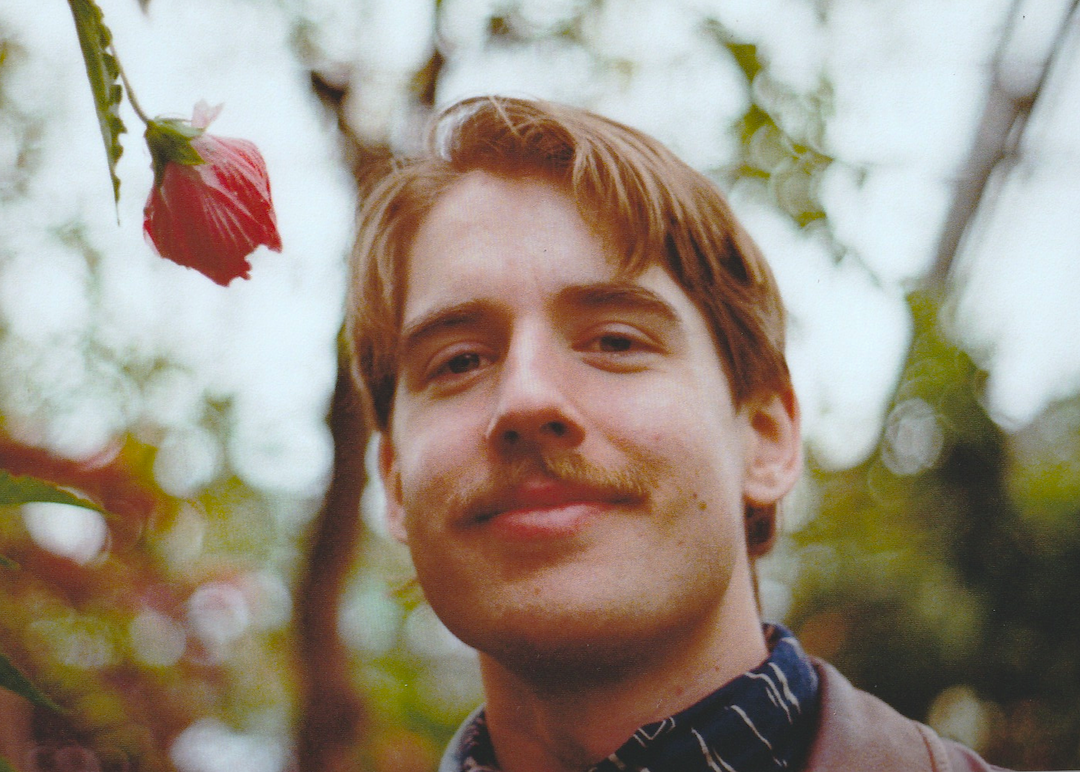 Jacob Szutka headshoot: outdoors, smiling at the camera
